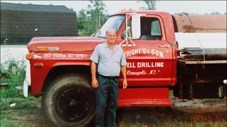 Lee Arthur “Bud” Wright standing beside the red Wright’s & Son Well Drilling truck, lettered Kannapolis, N.C.
